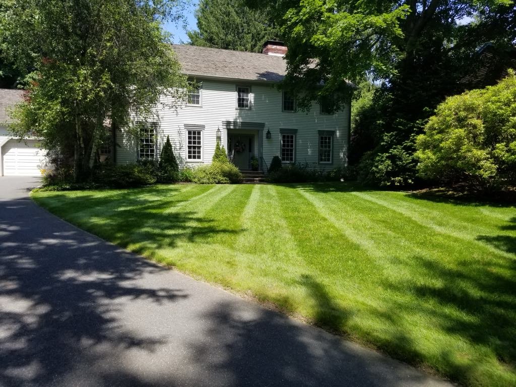 Perfectly striped green lawn in front of a colonial-style home in Danvers, MA